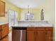 Bright kitchen features stainless steel dishwasher, wood cabinets and a view of the patio at 2321 Oberwood Dr, Charlotte, NC 28270