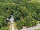 An aerial view of a home and detached garage with wooded areas, offering both seclusion and accessibility at 2345 Stallings Rd, Matthews, NC 28104