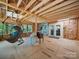 Unfinished bonus room features exposed wood walls, beams and joists, hardwood flooring, and a hanging hammock chair at 2345 Stallings Rd, Matthews, NC 28104