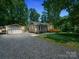 Charming single story home featuring a detached garage, gravel driveway, and a welcoming wooden deck at 2345 Stallings Rd, Matthews, NC 28104