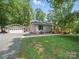 Charming single story home featuring a detached garage, gravel driveway, and a welcoming wooden deck at 2345 Stallings Rd, Matthews, NC 28104