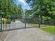 View of the home through iron security gate and fence, which enhances privacy at 2345 Stallings Rd, Matthews, NC 28104