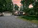 Charming home with a detached garage and well-manicured lawn, nestled in a peaceful, wooded setting at 2345 Stallings Rd, Matthews, NC 28104