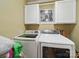 Modern laundry room with a front loading washer and dryer and upper cabinets at 2345 Stallings Rd, Matthews, NC 28104