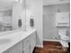 Bright bathroom featuring double sink vanity, large mirror, and hardwood floors at 2467 Hawk Ridge Dr, Gastonia, NC 28056