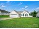 Charming single-story home featuring a spacious lawn, attached garage, and bright green shutters under a blue sky at 2467 Hawk Ridge Dr, Gastonia, NC 28056