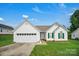 Inviting single-story home with a well-kept lawn, white siding, green shutters, and a two-car garage at 2467 Hawk Ridge Dr, Gastonia, NC 28056