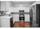 Well lit kitchen featuring white cabinets, stainless steel appliances, and hardwood floors at 2467 Hawk Ridge Dr, Gastonia, NC 28056