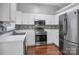 Well lit kitchen featuring white cabinets, stainless steel appliances, and hardwood floors at 2467 Hawk Ridge Dr, Gastonia, NC 28056