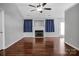 Bright living room featuring hardwood floors, a cozy fireplace, and blue curtains at 2467 Hawk Ridge Dr, Gastonia, NC 28056
