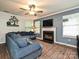 Cozy living room featuring a fireplace, ceiling fan, comfortable couch, and plenty of natural light at 2848 Huckleberry Hill Dr, Fort Mill, SC 29715