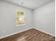 Bedroom provides wood-look flooring and a window with wooded street views at 3133 Amay James Ave, Charlotte, NC 28208