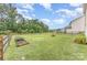 Wide backyard features green lawn, a fire pit, and trees at 3304 Saddlebrook Dr, Midland, NC 28107