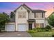 Charming two-story home featuring a two-car garage, landscaped front yard and a welcoming entrance, 