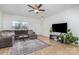 Well-lit living room with a comfortable sectional sofa, hardwood floors, and large screen tv at 3304 Saddlebrook Dr, Midland, NC 28107