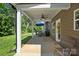 Back patio complete with ceiling fan, stone supports, a grill and grassy backyard at 3963 Harmattan Dr, Denver, NC 28037