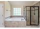 Bathroom featuring a soaking tub, a glass shower, and a bright window at 3963 Harmattan Dr, Denver, NC 28037