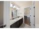 Well-lit bathroom featuring double sinks, framed mirror, and view into the next room at 3963 Harmattan Dr, Denver, NC 28037