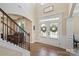 Elegant foyer featuring a staircase with rod iron spindles, hardwood floors, and an inviting double door entrance at 3963 Harmattan Dr, Denver, NC 28037