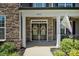 Inviting front entrance with double doors adorned with wreaths, framed by stone accents and a charming porch at 3963 Harmattan Dr, Denver, NC 28037