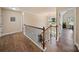 Hallway with wood floors, elegant banister, and natural light streaming through nearby window at 3963 Harmattan Dr, Denver, NC 28037
