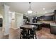 Bright open kitchen with dark cabinets, granite countertops, and a central island with seating at 3963 Harmattan Dr, Denver, NC 28037