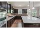 Well-equipped kitchen with dark cabinets, granite countertops, and stainless steel appliances at 3963 Harmattan Dr, Denver, NC 28037