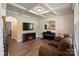 Cozy living room featuring coffered ceilings, hardwood floors, and a fireplace with an electric insert at 3963 Harmattan Dr, Denver, NC 28037