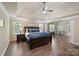 Spacious main bedroom featuring a tray ceiling, hardwood floors and abundant natural light from surrounding windows at 3963 Harmattan Dr, Denver, NC 28037
