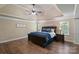 Bright main bedroom featuring hardwood floors, a ceiling fan, and a decorative tray ceiling at 3963 Harmattan Dr, Denver, NC 28037
