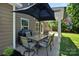 Outdoor patio area featuring a grill, dining table, and an umbrella for shade at 3963 Harmattan Dr, Denver, NC 28037