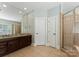 Bathroom features double vanity, large mirror, framed shower with glass door and neutral paint at 4218 Ash Hollow Ln, Denver, NC 28037