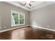 Bright bedroom featuring hardwood floors, large window, ceiling fan, and tray ceiling at 4218 Ash Hollow Ln, Denver, NC 28037