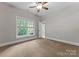 Well-lit bedroom with a ceiling fan and large window overlooking the exterior landscape at 4218 Ash Hollow Ln, Denver, NC 28037