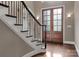Bright foyer featuring a staircase with iron railings and a glass paneled double door at 4218 Ash Hollow Ln, Denver, NC 28037