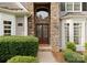 Close-up of stone entrance, double front doors, a 'Welcome' mat, and manicured landscaping at 4218 Ash Hollow Ln, Denver, NC 28037