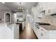 Open kitchen features white cabinets, stainless appliances, and granite counters and hardwood floors at 4218 Ash Hollow Ln, Denver, NC 28037