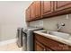 Functional laundry room with modern washer, dryer, sink, and cabinetry at 4218 Ash Hollow Ln, Denver, NC 28037