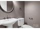 Elegant powder room with a pedestal sink, modern faucet, and toilet at 4218 Ash Hollow Ln, Denver, NC 28037