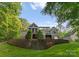 Back exterior featuring tiered landscaping, a screened porch, and multiple windows at 4218 Ash Hollow Ln, Denver, NC 28037