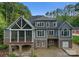 Back exterior featuring a stone patio, screened porch, and multiple windows at 4218 Ash Hollow Ln, Denver, NC 28037
