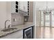 Wet bar features granite countertops, a wine fridge, and white cabinets with a view to the dining room at 4218 Ash Hollow Ln, Denver, NC 28037