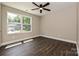 Sunlit bedroom showcasing hardwood floors, a ceiling fan, and a window overlooking the yard at 446 Mint St, Rock Hill, SC 29730
