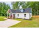 Well-manicured lawn surrounds a delightful cottage-style home with white siding at 516 North Mulberry St, Cherryville, NC 28021