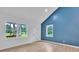 Bright living room with natural light, a white front door, three large windows, and neutral walls highlighting the wood-look floors at 516 North Mulberry St, Cherryville, NC 28021