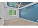 Serene main bedroom featuring tray ceilings, a ceiling fan, and neutral walls enhancing the natural light from the large windows at 516 North Mulberry St, Cherryville, NC 28021