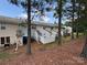 View of the townhouse back exteriors with fenced patios and a wooded backdrop at 5650 Kimmerly Woods Dr, Charlotte, NC 28215