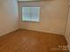 A bedroom with wooden floors and a window that allows for natural light at 5650 Kimmerly Woods Dr, Charlotte, NC 28215