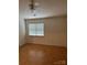 Simple bedroom with a ceiling fan, large window, and closet, providing a clean and functional space at 5650 Kimmerly Woods Dr, Charlotte, NC 28215