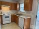 Cozy kitchen featuring oak cabinets, a white dishwasher, and a stainless steel sink at 5650 Kimmerly Woods Dr, Charlotte, NC 28215